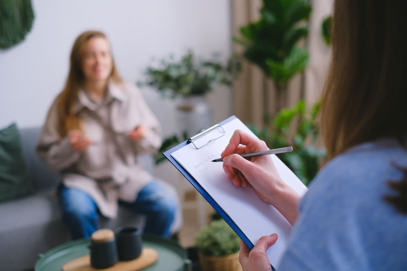An adviser taking notes while meeting a client